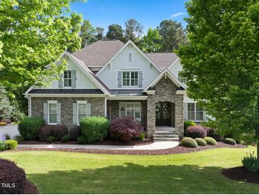 Charming two-story home featuring stone accents, lush landscaping, and a well-manicured lawn at 6829 Palaver Ln, Cary, NC 27519