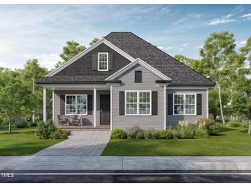 Charming single-story home boasts gray siding, black shutters, inviting front porch, and well-manicured landscaping at 15 Bourbon St, Fuquay Varina, NC 27526