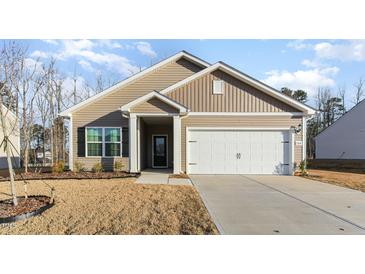 Charming single-story home featuring a well-manicured lawn and a convenient attached two-car garage at 504 Rhino Bnd, Oxford, NC 27565
