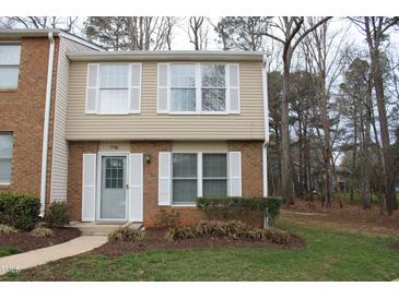 Charming townhouse with brick and beige siding, complemented by white window shutters and a well-maintained lawn at 7746 Kingsberry Ct, Raleigh, NC 27615