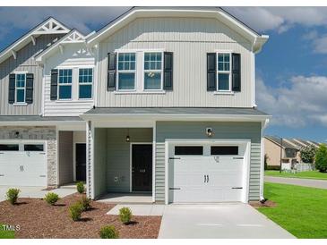Charming two-story townhome featuring a one-car garage, and a cozy covered entry, complemented by manicured landscaping at 129 Rolesville Ridge Dr, Rolesville, NC 27571