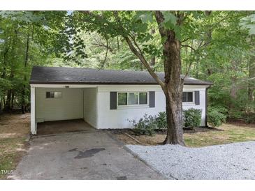 Charming one-story home featuring a carport, a light-colored brick exterior, and a well-maintained landscaped yard at 1706 Us Hwy 70A E, Hillsborough, NC 27278
