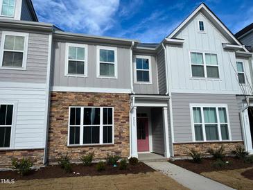 Charming townhome with stone accents, a light pink door, and manicured landscaping at 2335 Whitewing Ln, Wendell, NC 27591