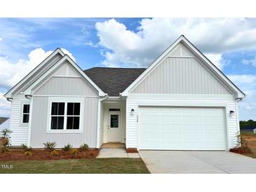 Charming single-story home featuring white siding, a two-car garage, and lush front lawn at 338 Tormore Dr, Homesite 123, Sanford, NC 27330