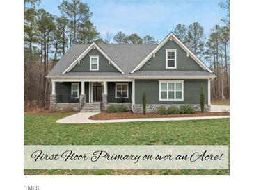 Charming single-story home with a beautifully landscaped front yard and a welcoming covered porch at 85 Willow Bend Dr, Youngsville, NC 27596