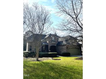 Traditional brick home with well-manicured lawn and landscaping, complemented by mature trees and an attached garage at 101 Tussled Ivy Way, Cary, NC 27513