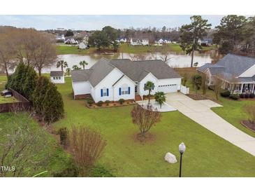 Beautiful lakefront home featuring white siding, blue shutters, mature landscaping, and a long driveway at 123 Glasgow Dr, Clayton, NC 27520