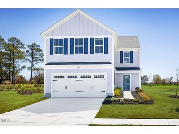 Charming two-story home featuring light blue siding, a two-car garage, and blue shutters at 133 Cavalier Rider Run, Wendell, NC 27591