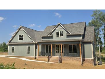 Charming two-story home with a covered front porch, complemented by brick accents and a well-manicured lawn at 2833 Faucette Ln, Burlington, NC 27217