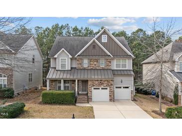 Charming two-story home with stone accents, attached two-car garage, and well-maintained landscaping at 5213 Orabelle Ct, Raleigh, NC 27606