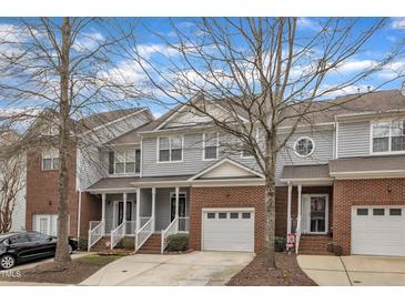 Charming brick townhome with garage and covered porch with mature trees and manicured landscaping at 6013 Kohler Ln, Raleigh, NC 27616
