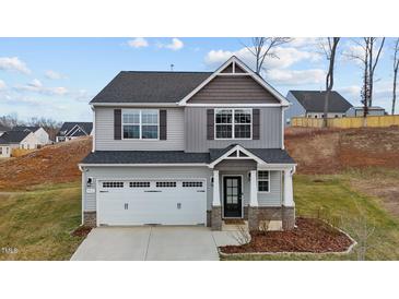 Charming two-story home featuring gray siding, a two-car garage, and a well-manicured front yard at 106 Jared Ct, Graham, NC 27253
