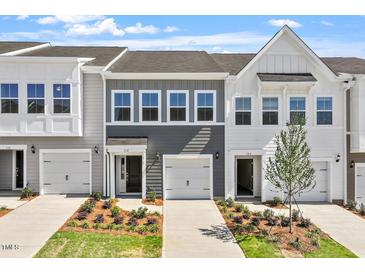 Charming townhome featuring a well-manicured lawn, a one car garage, and a welcoming entrance at 112 Central Townes Way # 294, Raleigh, NC 27603