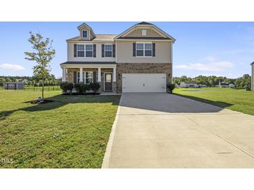 Charming two-story home featuring a welcoming front porch and attached two-car garage at 147 Young Farm Dr, Lillington, NC 27546