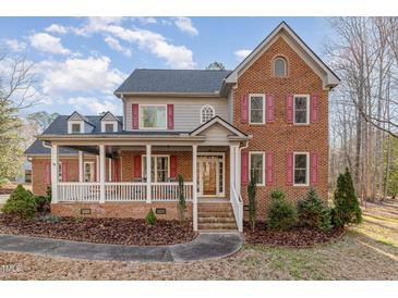 Charming two-story brick home with a welcoming front porch and red shutters at 1532 Rockwood Downs Dr, Wendell, NC 27591