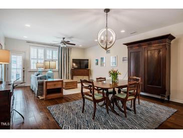 Open-concept living and dining area featuring hardwood floors and natural light at 211 Monarda Way, Hillsborough, NC 27278
