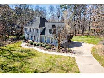 Charming two-story home with a landscaped yard and a welcoming blue front door at 2309 Laurelford Ln, Wake Forest, NC 27587