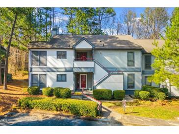 Inviting condo with well-maintained landscaping, red door, and second story balcony at 32 Melstone Turn, Durham, NC 27707