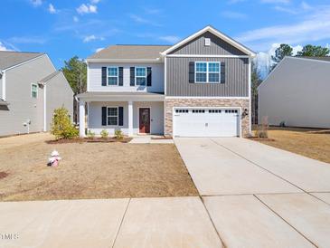Traditional two-story home with a two-car garage and a well-manicured lawn at 325 Azalea Gaze Dr, Youngsville, NC 27596
