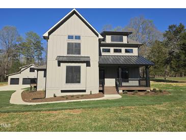 Charming two-story home with neutral siding, dark trim, and a welcoming front porch at 3601 Bivins Rd, Hillsborough, NC 27278