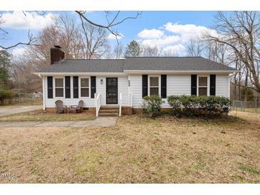 Charming single-story home featuring a well-maintained front yard and cozy front porch seating area at 5144 Shield Cir, Raleigh, NC 27603