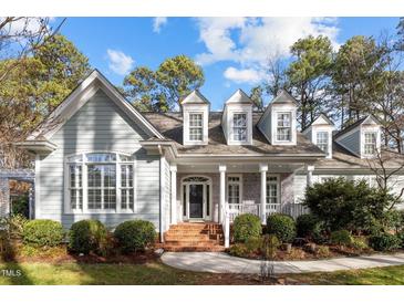 Charming home featuring light-green clapboard siding, white trim, brick accents, and a landscaped front yard at 5413 Leopards Bane Ct, Holly Springs, NC 27540