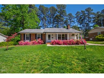 Charming single story home with beautiful landscaping and a lush green lawn at 5920 North Hills Dr, Raleigh, NC 27609