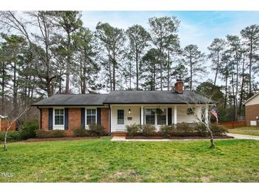 Charming one-story brick home with a well-maintained lawn and mature trees at 5920 North Hills Dr, Raleigh, NC 27609