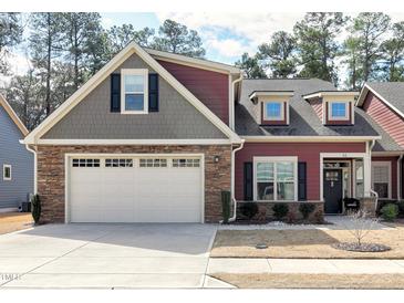 Charming home boasts a mix of stone and siding, complemented by a two-car garage and well-manicured landscaping at 80 Thornwhistle Pl, Garner, NC 27529