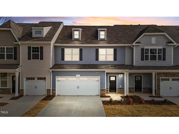 Charming townhome with a two-car garage, black shutters, and a welcoming front entrance at 803 Pryor St # 47, Mebane, NC 27302