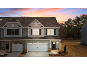 Charming two-story townhome featuring a one car garage and neutral siding with a meticulously maintained lawn at 807 Pryor St # 45, Mebane, NC 27302