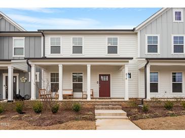 Inviting two-story townhome with a charming front porch and well-maintained landscaping at 814 Silo Park Dr, Wake Forest, NC 27587