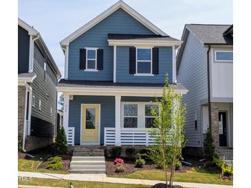 Charming two-story blue home featuring a welcoming front porch and bright yellow front door at 934 Allen Park Dr, Knightdale, NC 27604