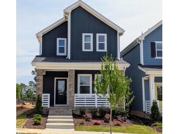 Charming two-story home featuring a welcoming front porch with beautiful landscaping and a modern color scheme at 936 Allen Park Dr, Raleigh, NC 27604