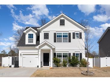 Charming two-story home featuring white siding, black shutters, manicured lawn, and attached garage at 121 Black Oak Ct, Clayton, NC 27520
