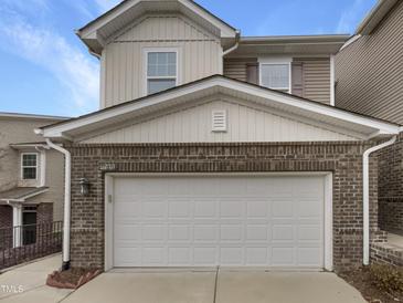 Attached two-car garage with white door and brick base on a two-story home at 1419 Glenwater Dr, Cary, NC 27519