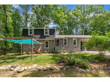 Charming gray home featuring a covered hammock area and lush greenery at 202 Brook Ln, Durham, NC 27712