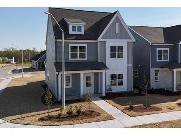 Charming two-story home with a mix of gray siding, white trim and a beautifully landscaped front yard at 2880 Quarry Rd # 163, Rolesville, NC 27571