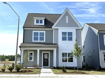 Charming two-story home featuring gray siding, white trim, and a welcoming front porch at 2880 Quarry Rd # 163, Rolesville, NC 27571