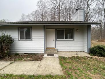 Exterior view of home featuring a white front door with two windows and a simple walkway to the entrance at 292 Cedar Lake Rd # A, Chapel Hill, NC 27516