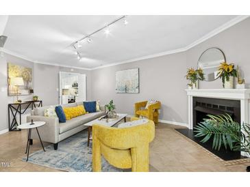 Bright living room features a cozy fireplace, stylish furniture, and neutral wall color at 308 Summerfield Crossing Road, Chapel Hill, NC 27514