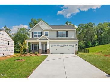 Charming two-story home with a two-car garage, gray siding, black shutters, and a well-maintained lawn at 511 Valentine Ct, Graham, NC 27253