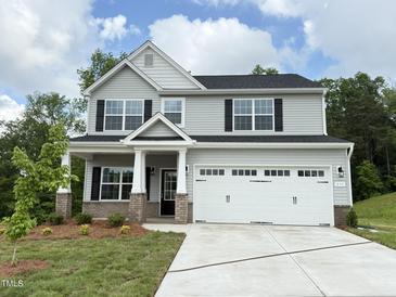 Charming two-story home with a gray exterior, a two-car garage, and a well-manicured front lawn at 511 Valentine Ct, Graham, NC 27253