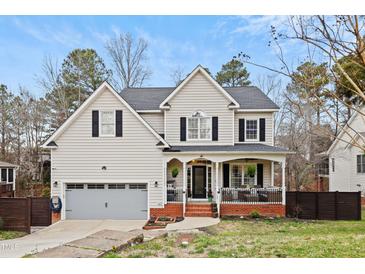 Charming two-story home with a welcoming front porch, well-maintained lawn, and attached garage at 512 Tryst Ln, Wake Forest, NC 27587