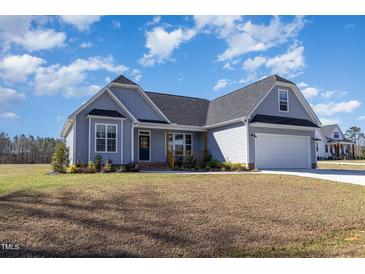 Charming single-Gathering home boasts light blue siding, a well-manicured lawn, and a two-car garage at 560 Waterstone Ln, Henderson, NC 27537