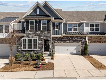 Beautiful townhome with a stone facade, two-car garage, and well-maintained landscaping at 8620 Secreto Dr, Raleigh, NC 27606