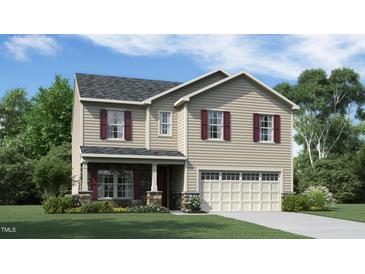Charming two-story home features a classic design, well-manicured lawn, and inviting curb appeal at 909 Thimbleweed Way, Wake Forest, NC 27587