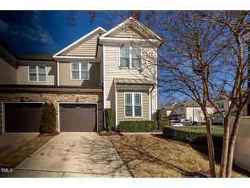 Two-story townhome featuring a tandem garage, stone accents and beautiful landscaping at 100 Pinto Saddle Ct, Garner, NC 27529