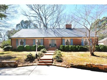 Charming brick home featuring a classic design, lush landscaping, and inviting curb appeal at 104 Parker St, Oxford, NC 27565