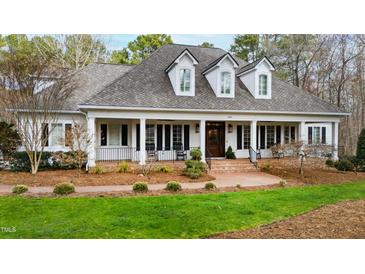Charming home featuring a brick walkway leading to a column-lined front porch with rocking chairs at 106 Woodkirk Ln, Chapel Hill, NC 27514